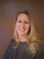 Head shot of Jennifer Vogel smiling and wearing a gray sweater 